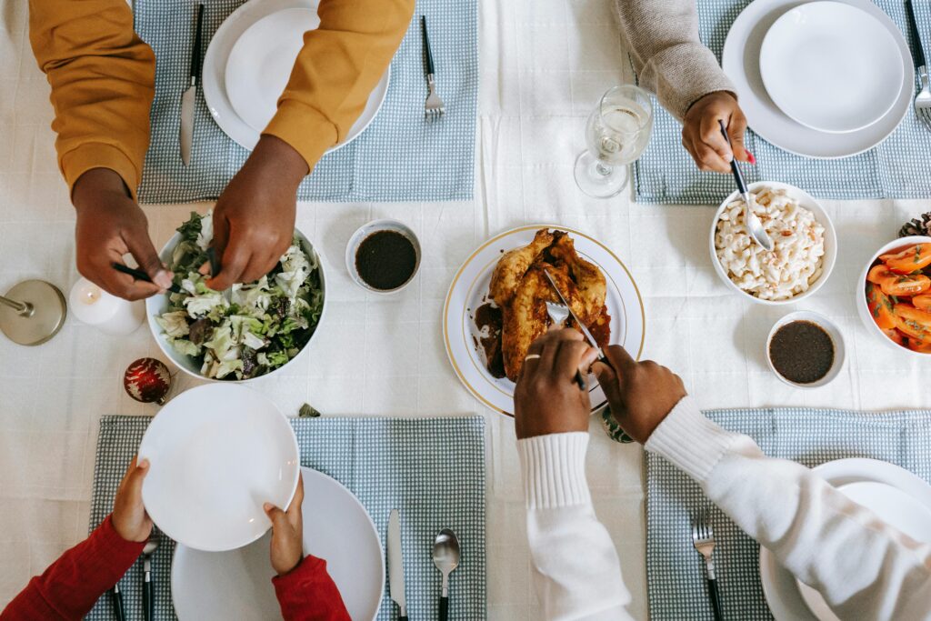 People around a table that has been set, preparing to eat