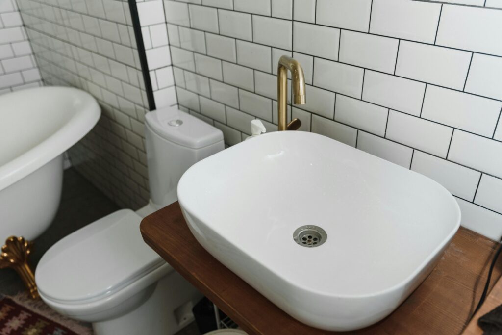 A bathroom sink, toilet and tiles